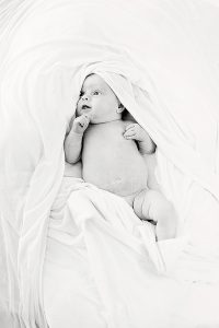 Foto van baby gedrappeerd in wit doek