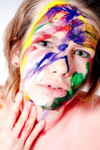 portretfoto met verf van meisje tijdens studioshoot
